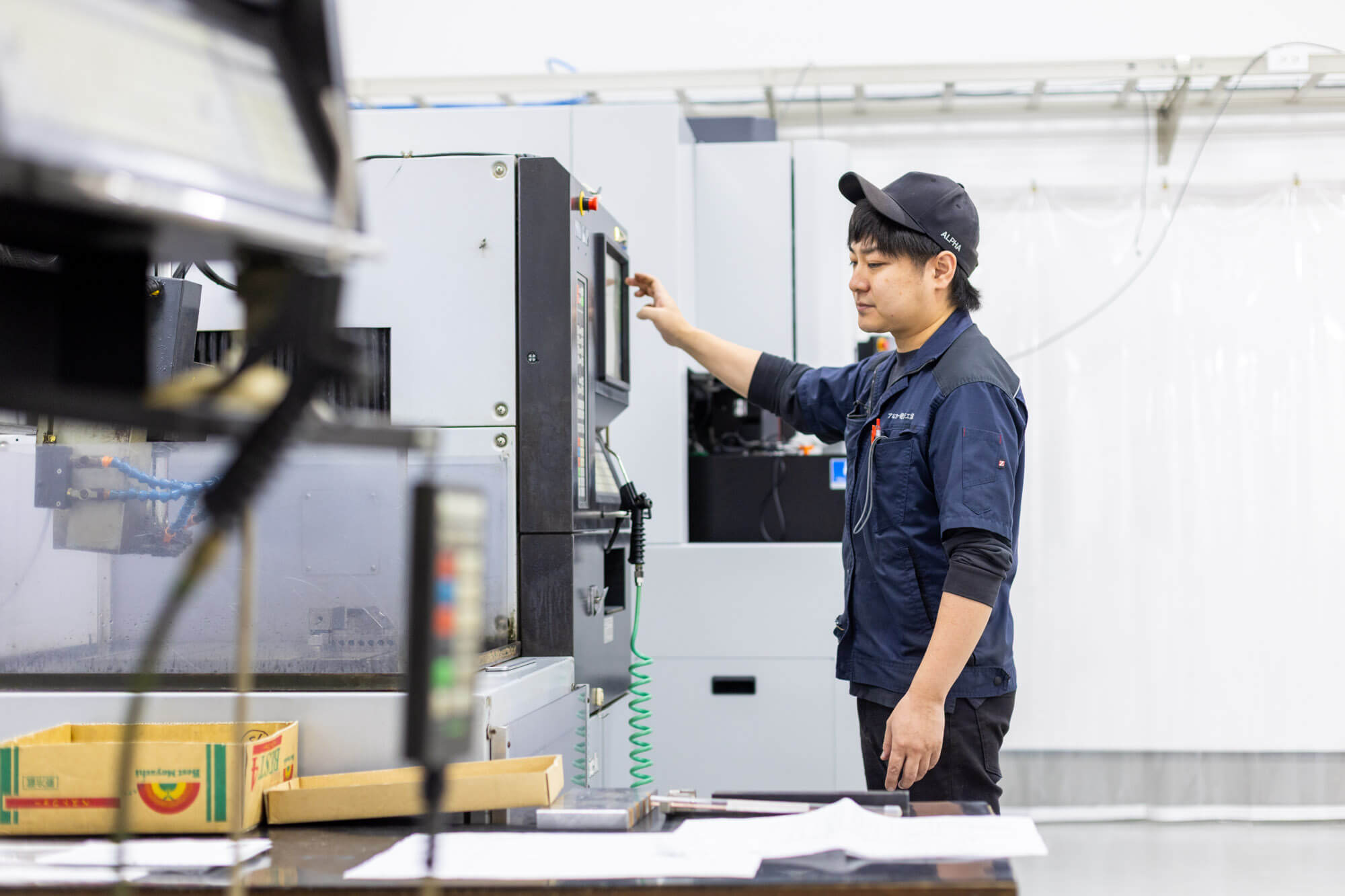 ワイヤーカット加工機の内部を確認する社員